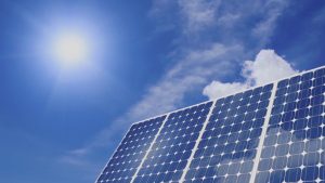 solar panels with a blue sky and sun in the background