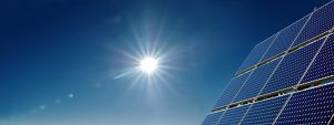 solar panels with a blue sky and sun in the background