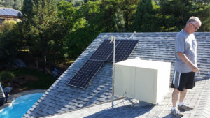 solar panels on a roof, a man pointing at something off camera