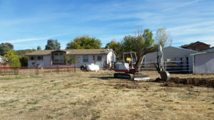 a backhoe with house in the background