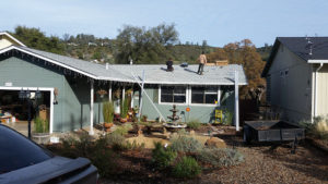 two men on a roof getting ready to install solar panels