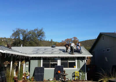 several men on top of a house installing solar panels