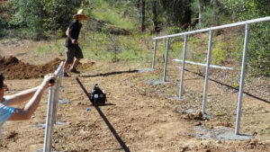 installing metal rods in ground for solar panels